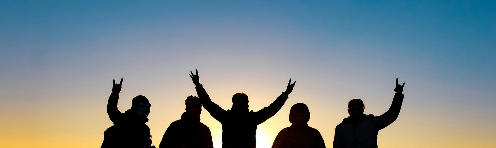 Silhouette of a team of five signaling success in victory.
