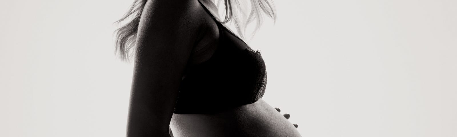 A pregnant woman in backlight.