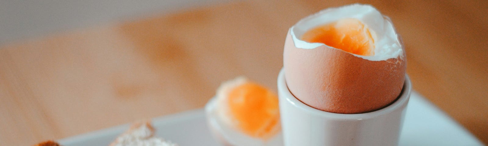 An open boiled egg stands in an egg cup, with toast ‘soldiers’ alongside