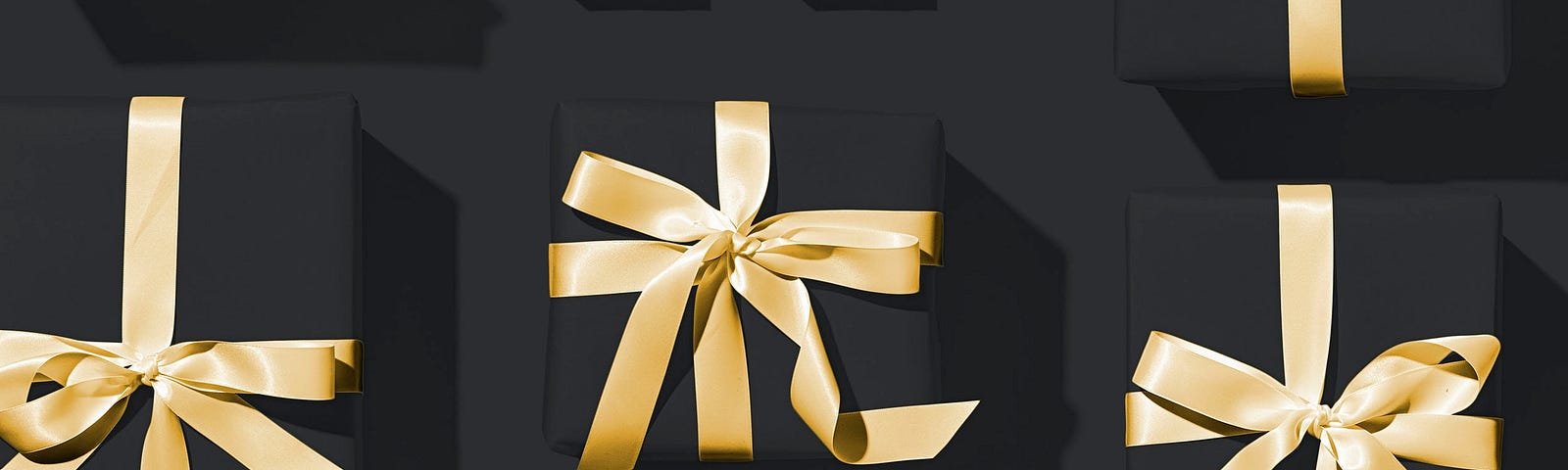image shows presents wrapped in gold on a black background
