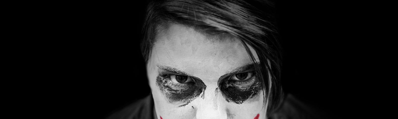 Very ugly clown. Black and white photo, but the clown smile is bright red. Makeup very poorly done.