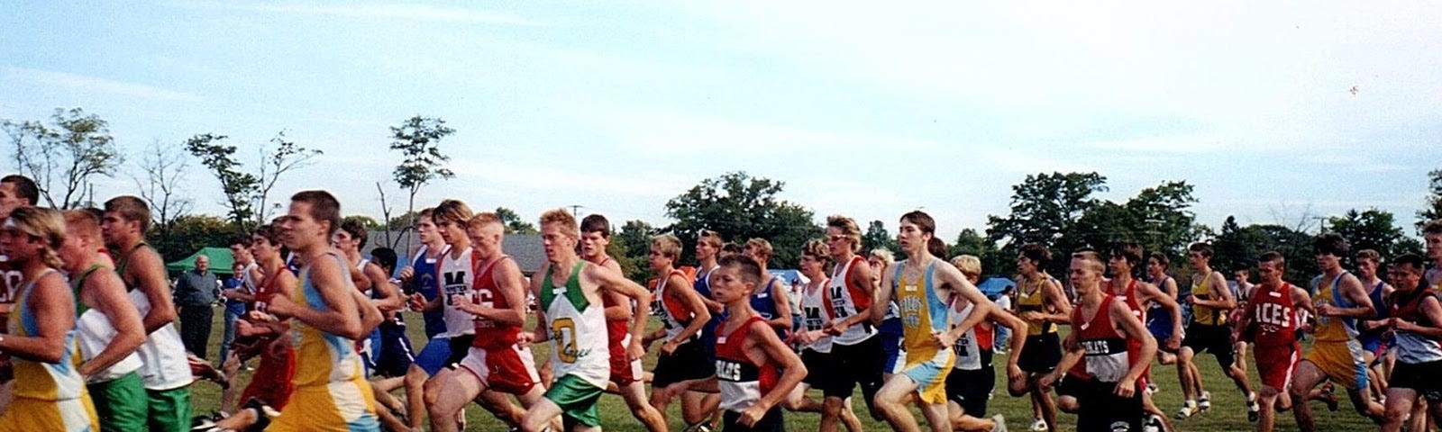 Luke Brenneman as a teen, center in red and black, running amongst many other teens, but very clearly smaller in stature.