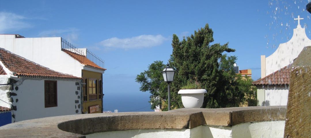 A fountain with typical Canary islands houses behind