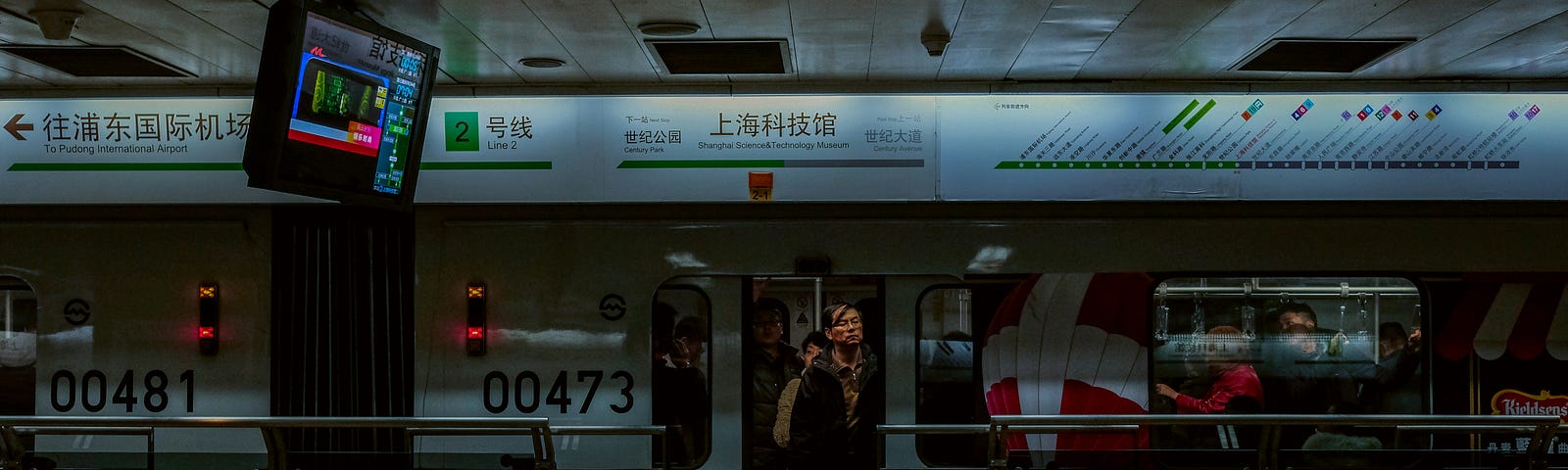 a subway train in a station. a man at the door getting on or off. The whole picture’s rather dark. Signs are in an Asian language.