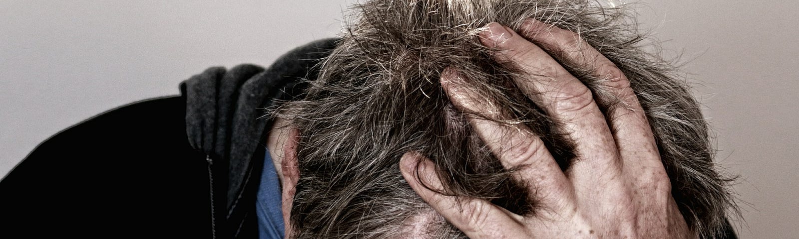 A man holding his head appearing to be exhausted.