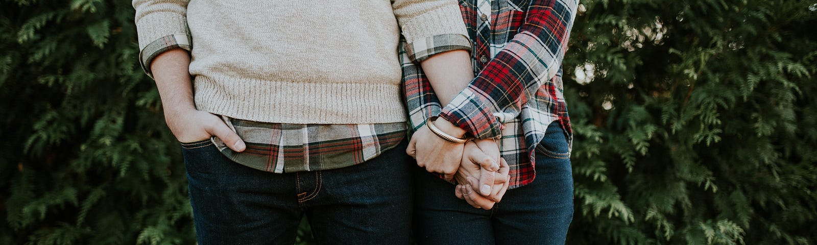 a couple facing the camera standing next to each other holding hands