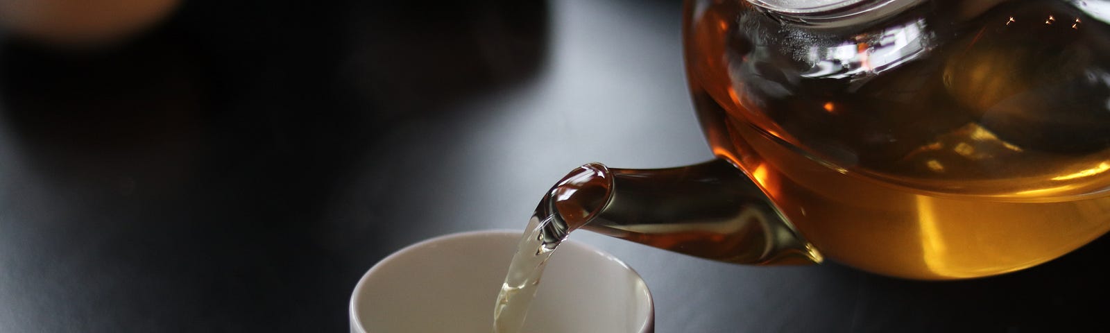 tea being poured into a cup from a teapot