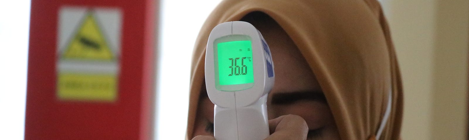 Woman getting her temperature tested