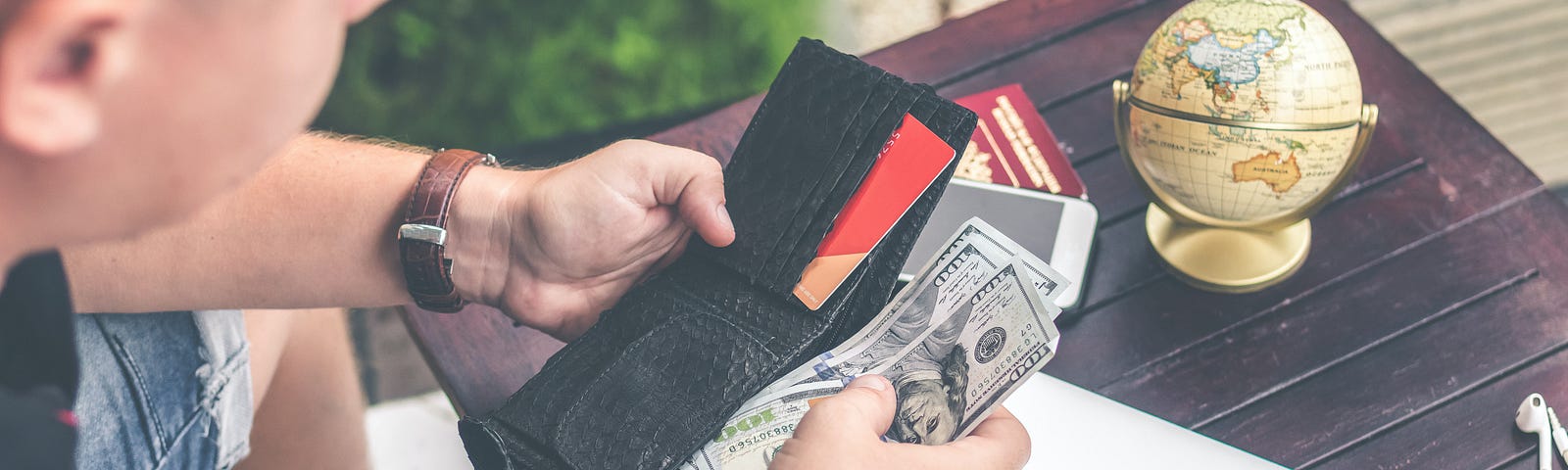 A man getting cash from his wallet.