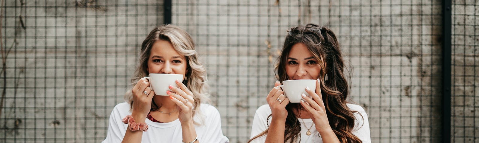 This shows two women holding coffee mugs.
