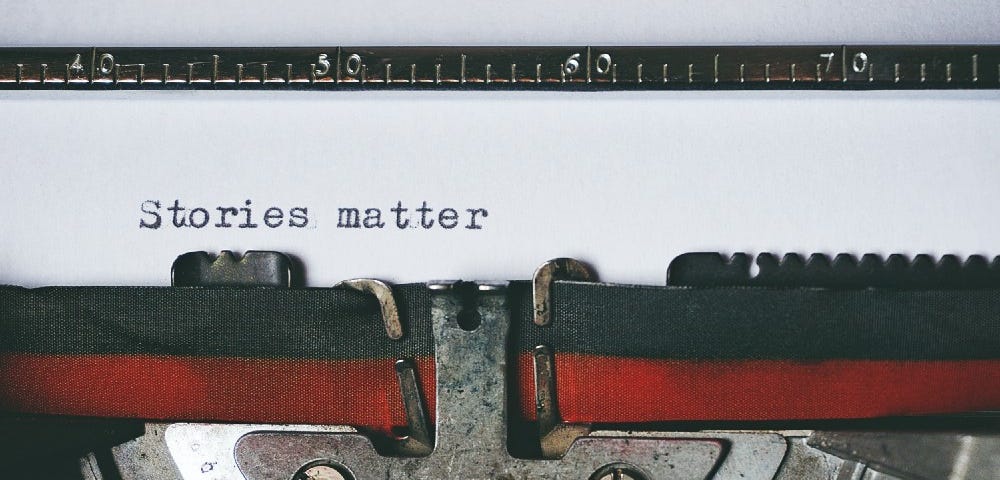 Typewriter with ribbon with “Stories matter” on the paper.