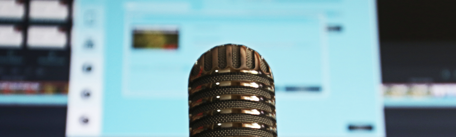 Closeup of a microphone with a computer screen in the background