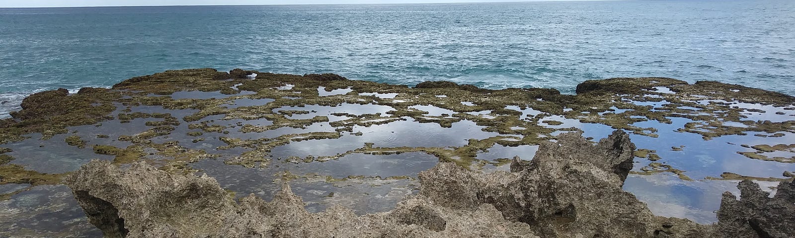 photo looking out over lava rock tide pools at Mermaid Caves area of Oahu, Hawaii