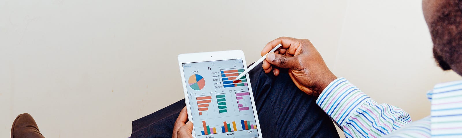 Man pointing to a graph on an electronic tablet.