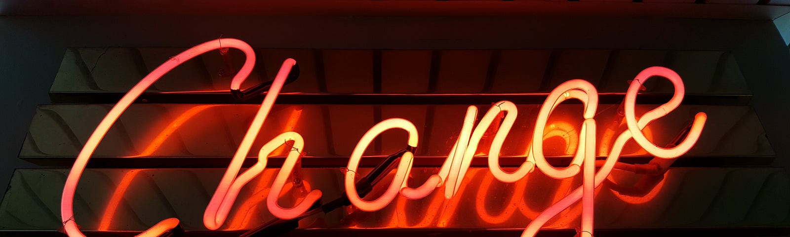 an orange/red neon sign with the word change