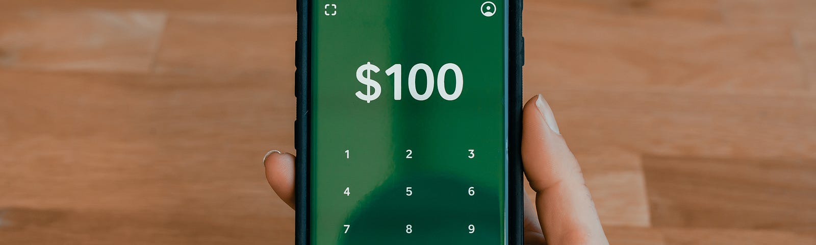 Online payment app on a mobile with $100 written on it.