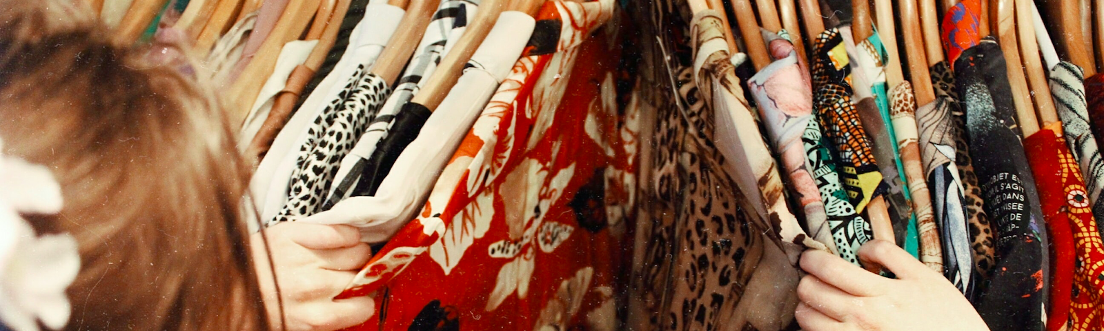 A person browsing colourfully printed tops.