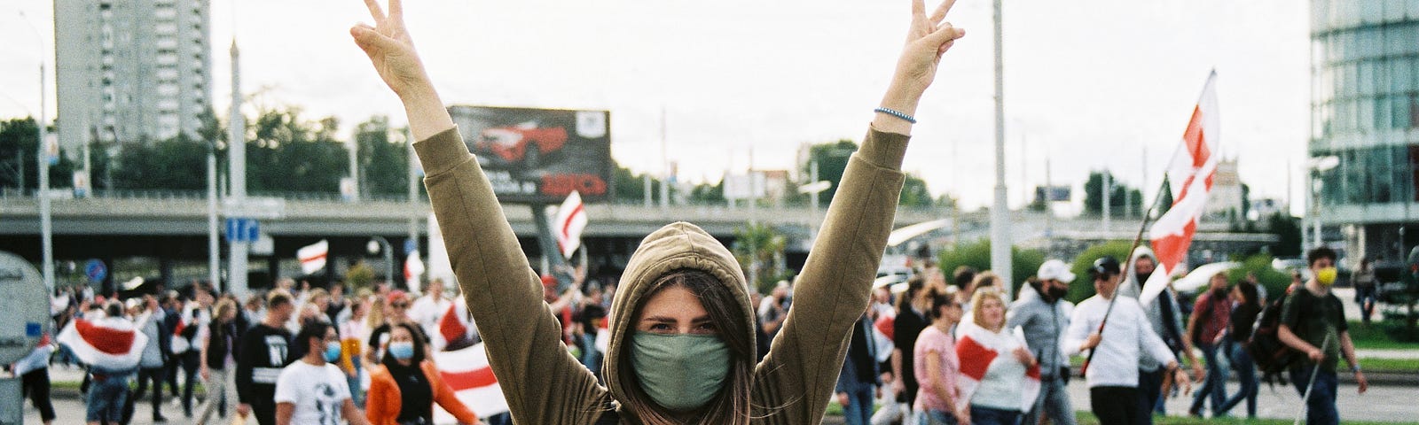 women with raised arms in front of barracaded street protest