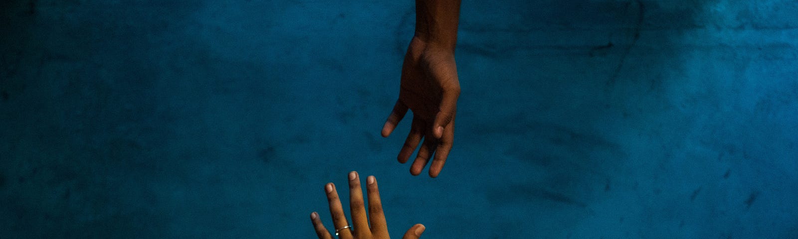 Hands reaching out to each other under water