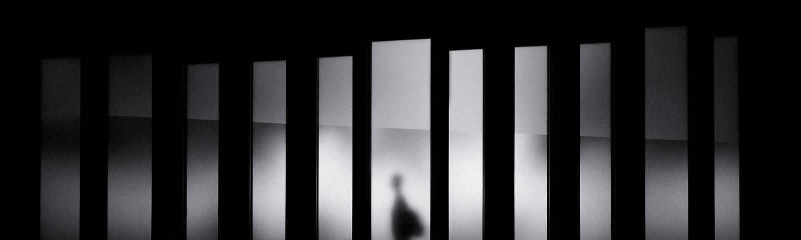 Person walks left, in the middle of one of a series of vertical strips of light (set against a black background). Walking is associated with a lower risk of dementia.