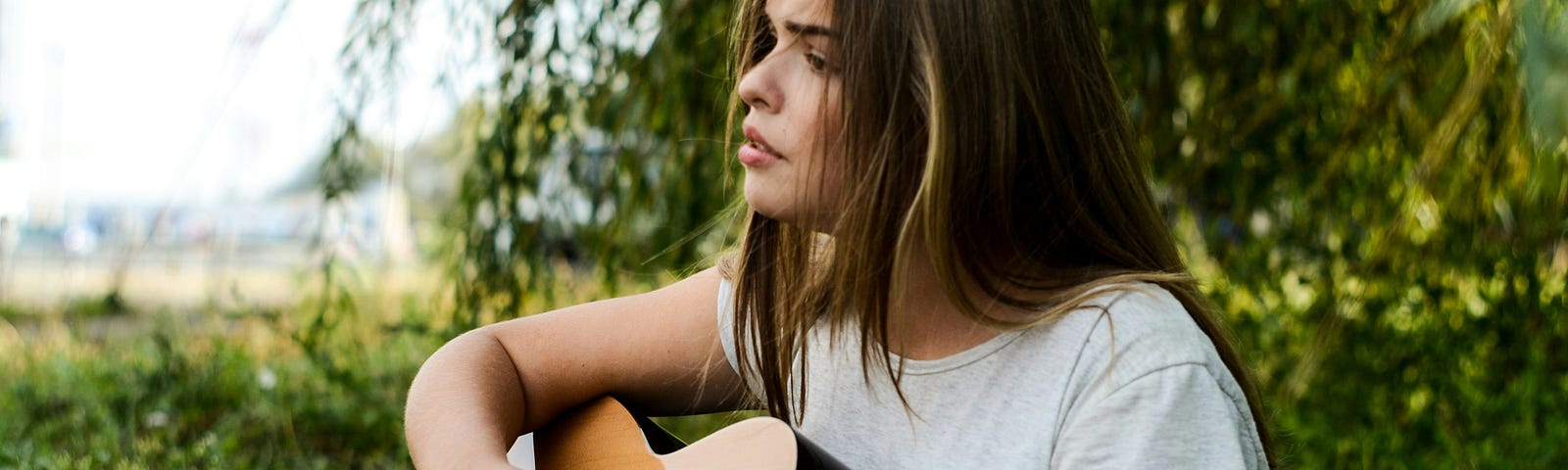 A girl outdoors with a guitar