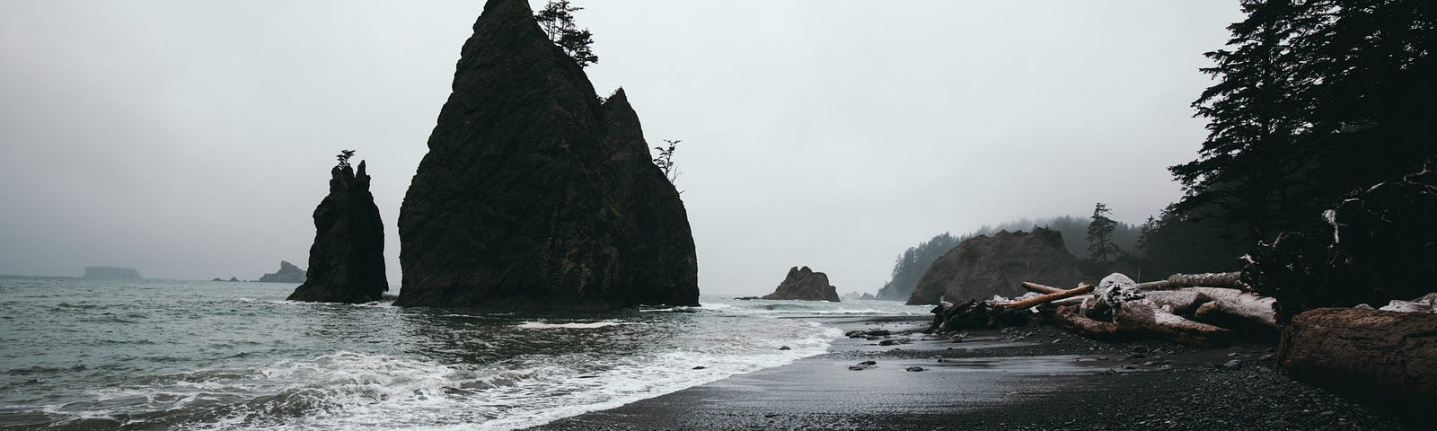 pacific ocean beach with large rocky outcrop in the foreshore