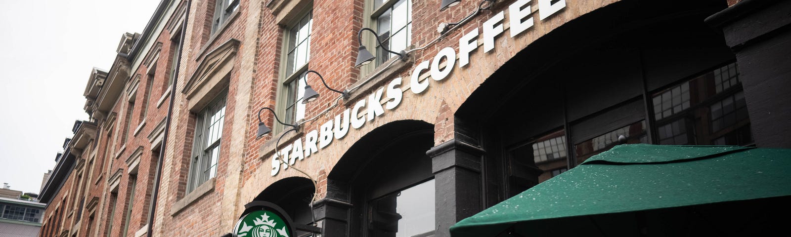 image shows the outside of a Starbucks within a brick building