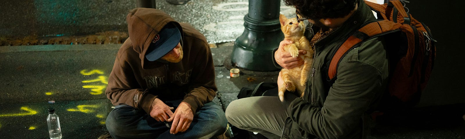 pic of 2 homeless people- with one holding a kitty