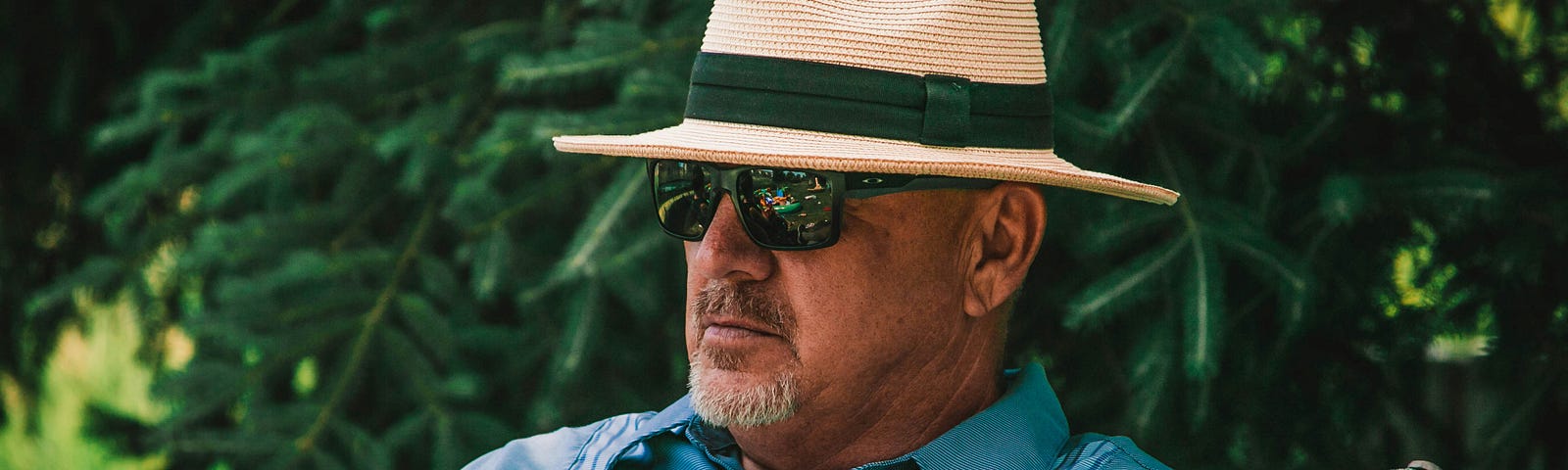 Man in Panama hat and sunglasses relaxing in a chair