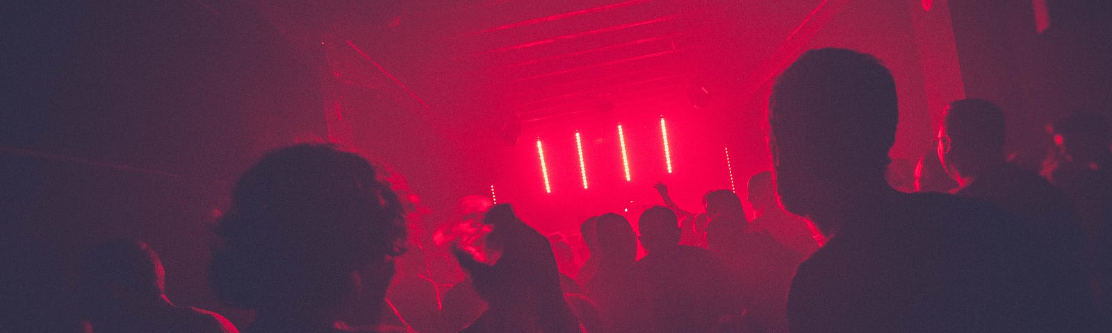 People in a room with red lighting.