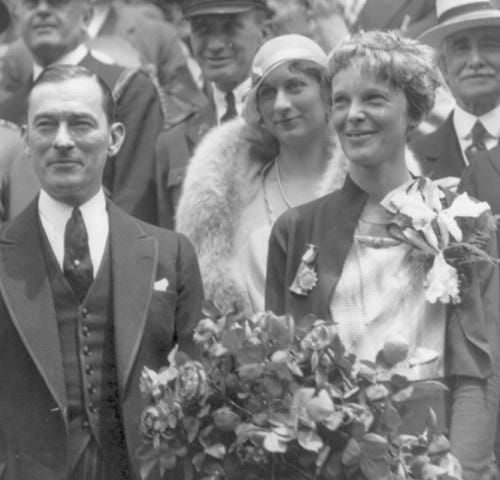 Amelia Earhart with flowers standing with MYC Mayor Walker