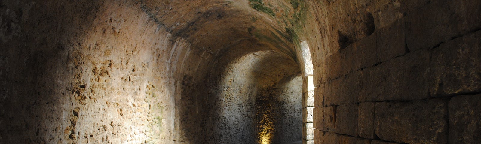 A stone tunnel curving away in the distance.