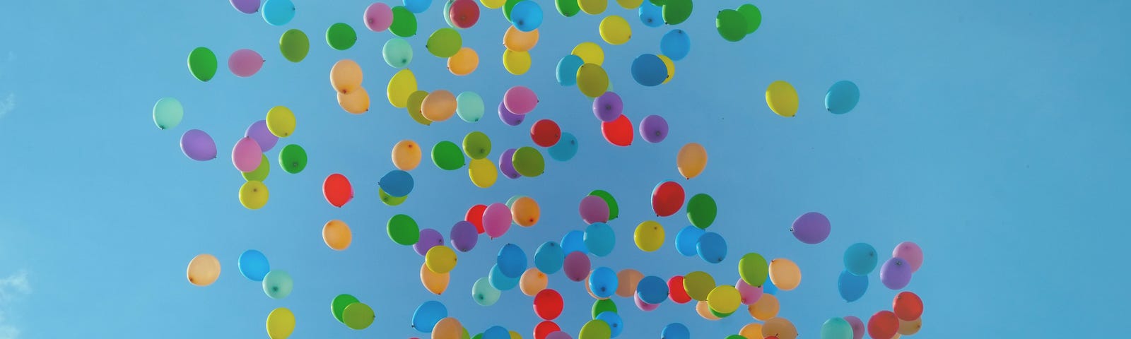 Hundreds of colored balloons in the blue sky