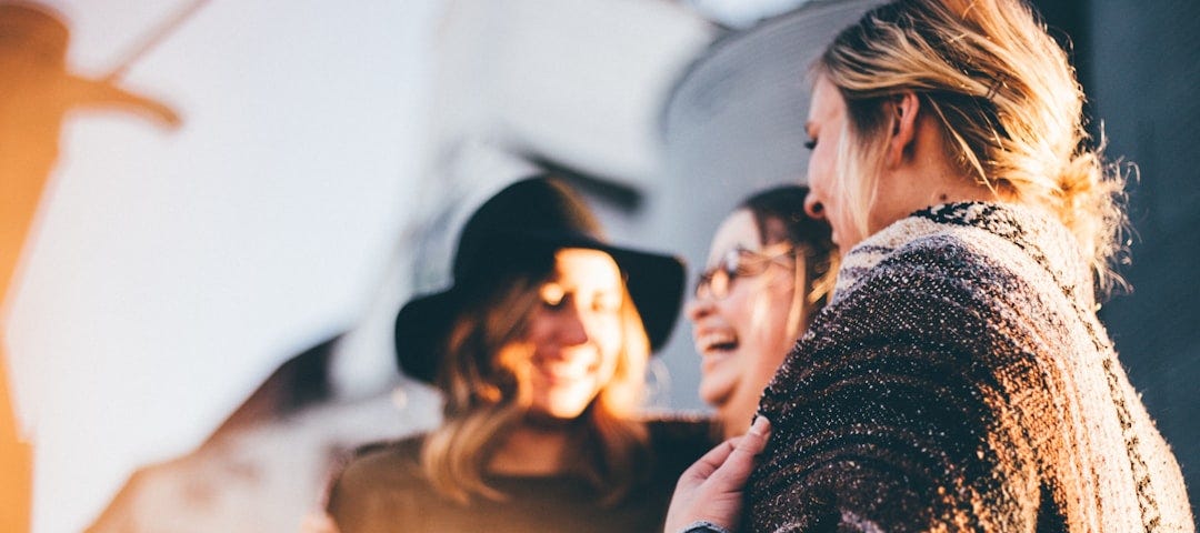 Friends laughing together in warm sunlight.