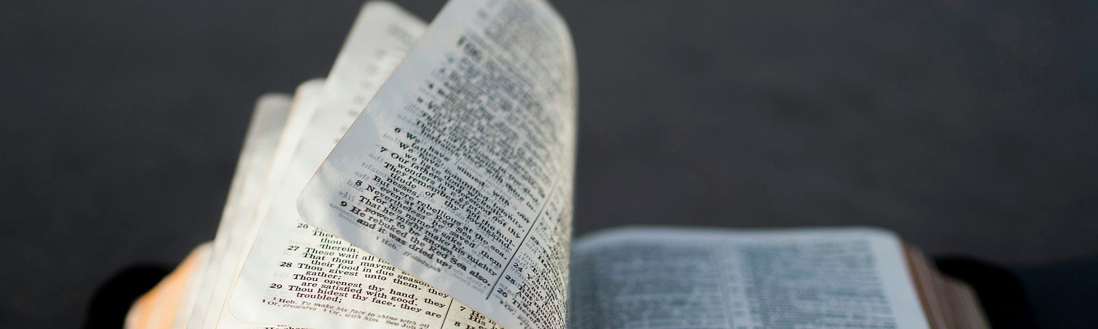 An open Bible with pages turning.