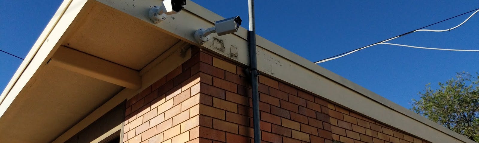 Two Umbo AiBullet cameras mounted on the side of an Urban Utilities building.