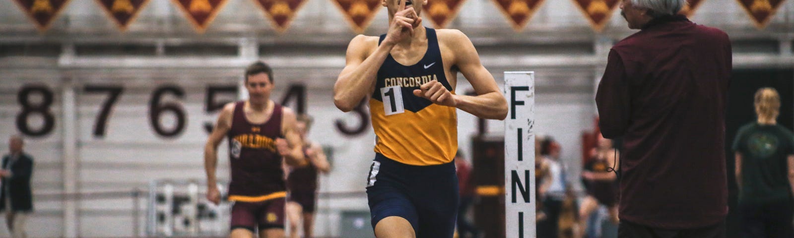 A young an finishes a race with his finger across his mouth expressing the keep shut sign.