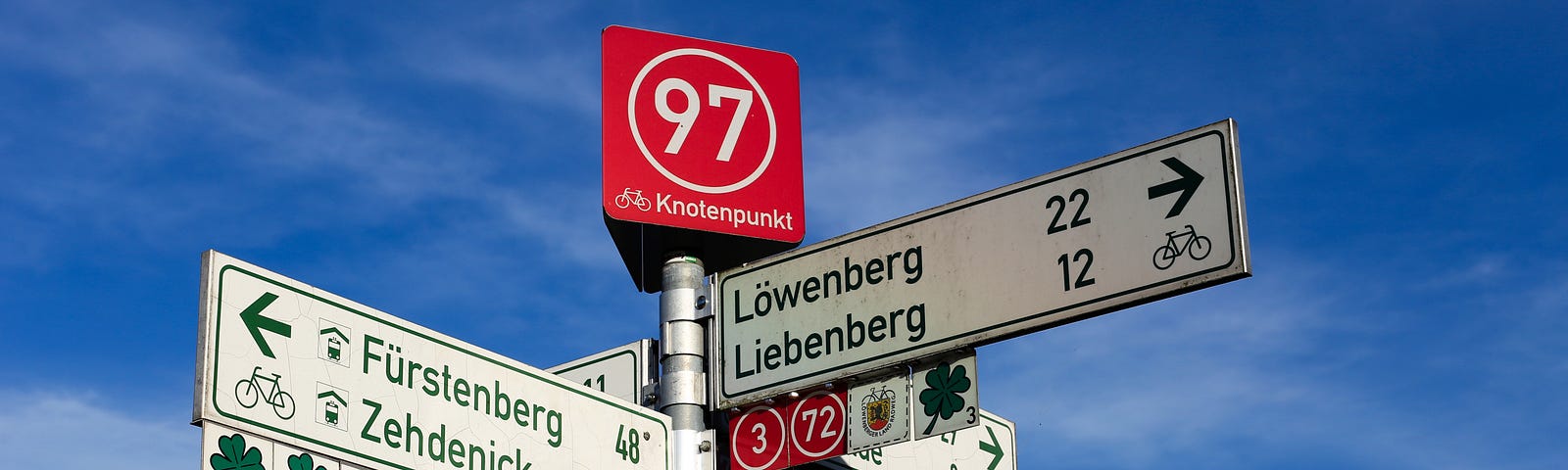 A German road sign showing distances by car and bike to nearby towns.