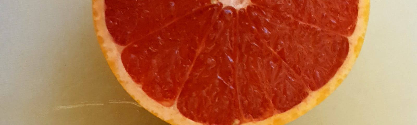 Half cut deep red grapefruit sitting face up with their 2 red halves showing | courtesy of author