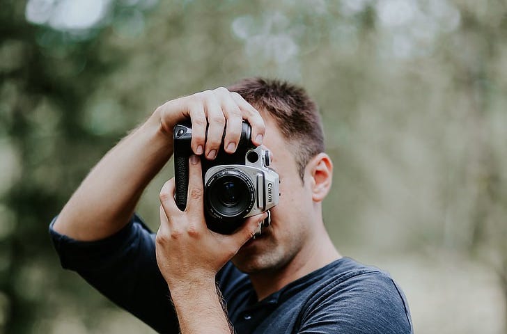 Man holding up a camera and taking a photo