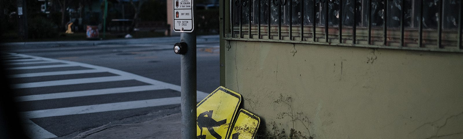 A broken pedestrian walking sign lying on the sidewalk