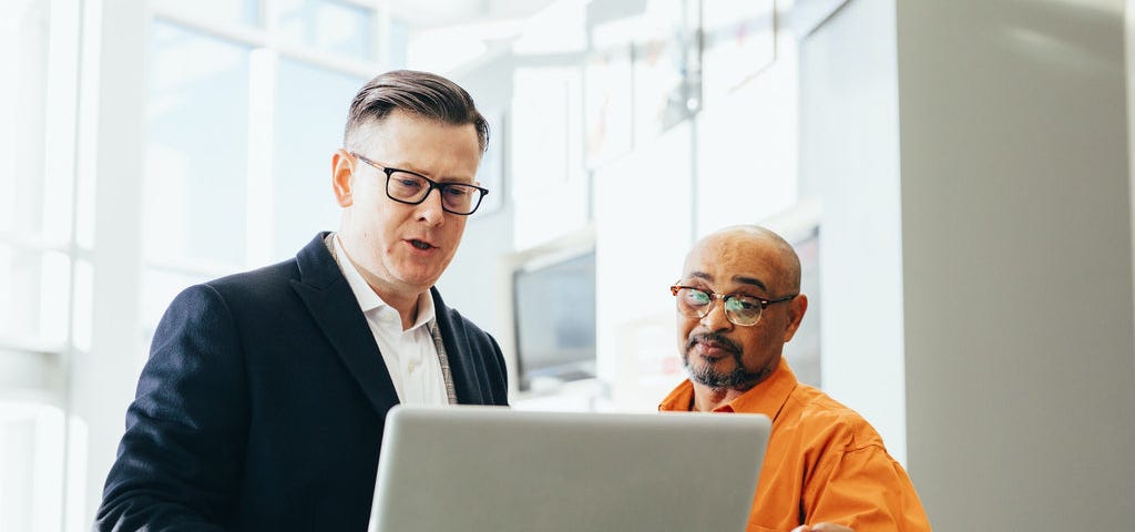 Two men working on a laptop