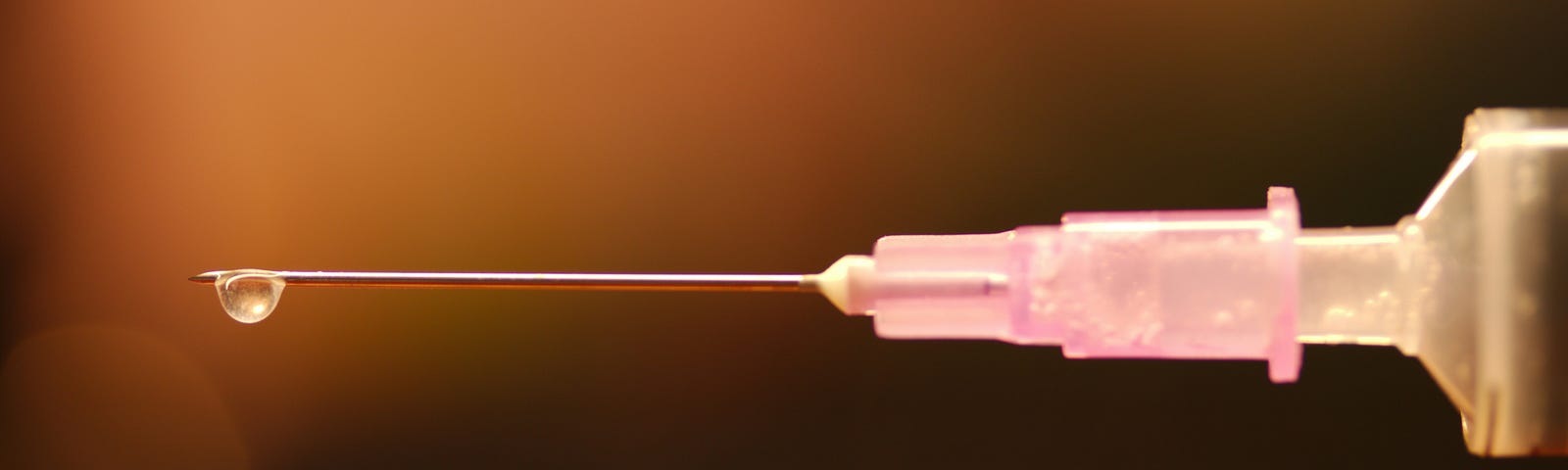 Liquid dripping off of a needle.