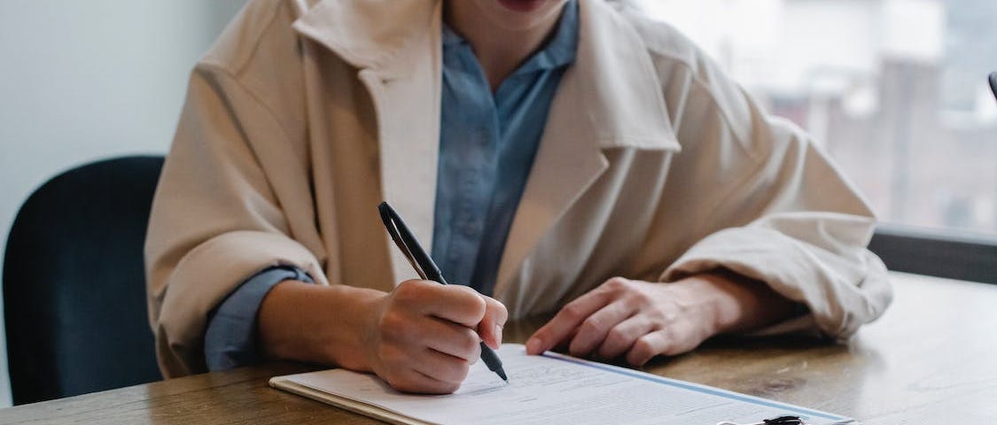 https://www.pexels.com/photo/focused-woman-writing-in-clipboard-while-hiring-candidate-5668869/