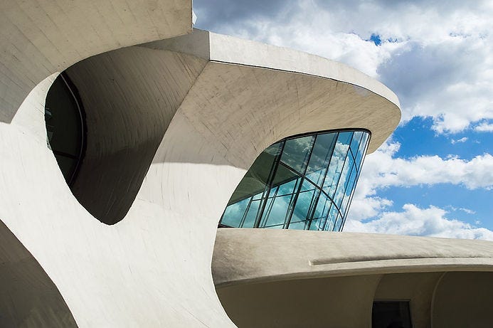 TWA Flight Center, designed by Eero Saarinen exterior showing the concrete forms and large glass panels. (Image source: Wikimedia Commons). Creative Commons license: CC BY-SA 4.0.