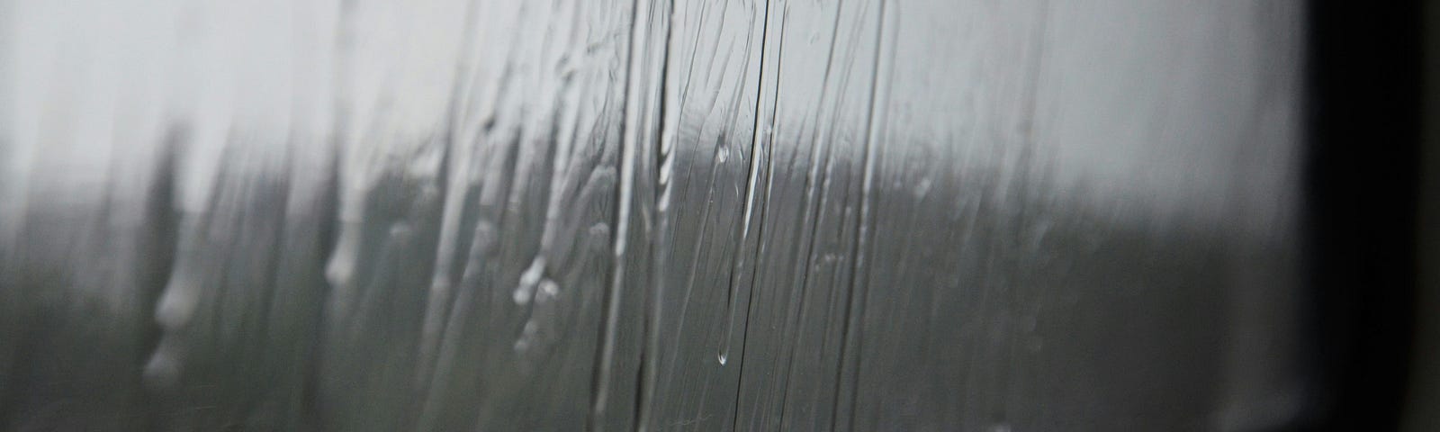 a rain-splashed window in black and white