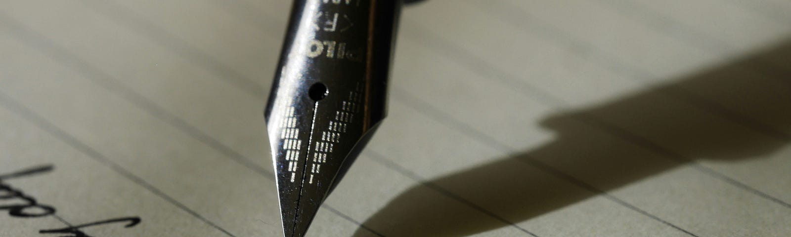 the tip of a pen writing on a paper
