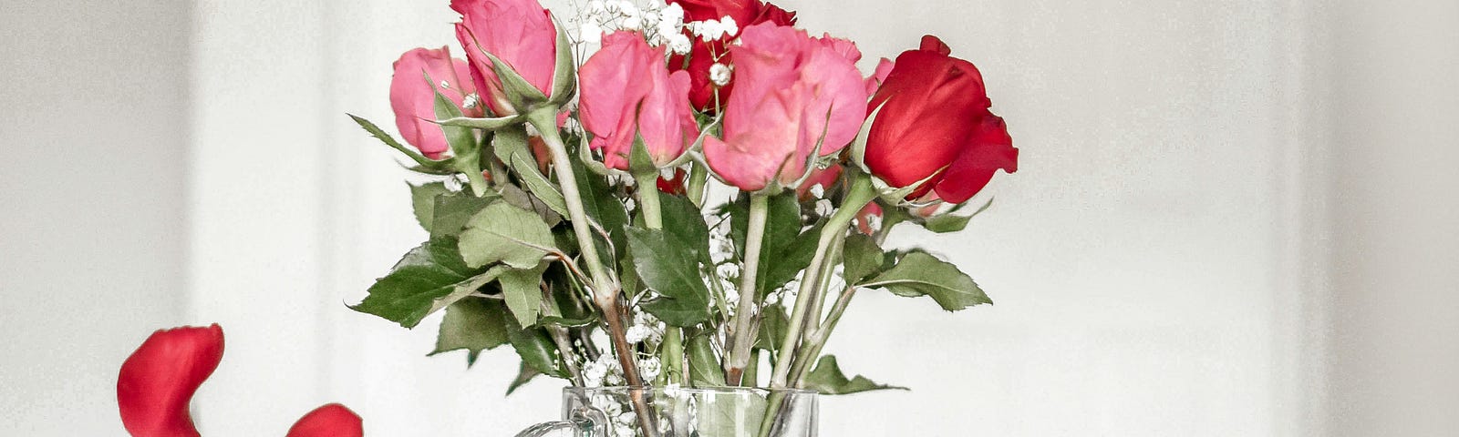 Rose petals following from a bouquet in a vase.