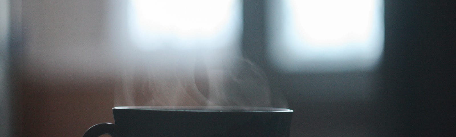 A small teacup with steam radiating from it