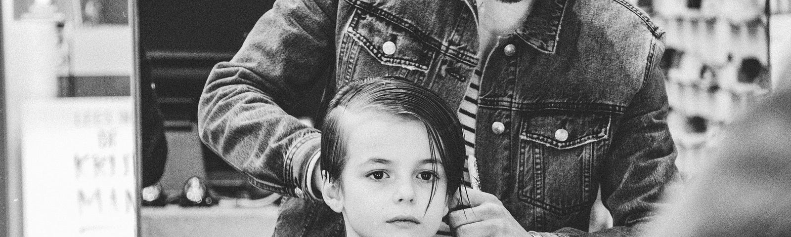 Black and white photo of young kid in barber chair